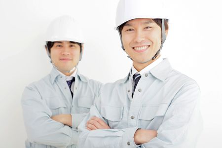 作業着とヘルメットを装着した笑顔の男性2人